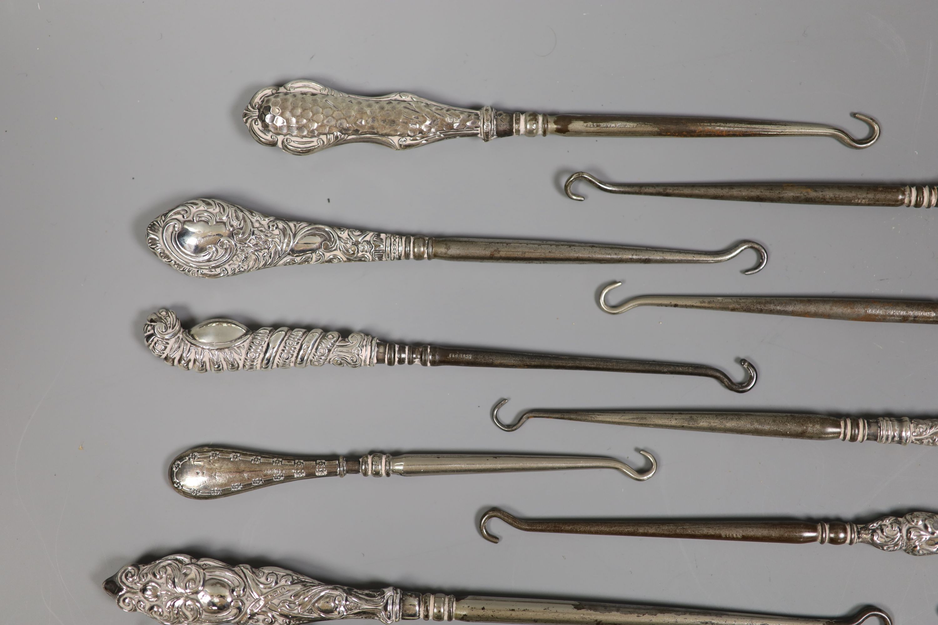 A collection of assorted silver handle button hooks and a nail implement.